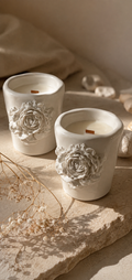 Dos velas artesanales LUMIERE ECLAT en recipiente cerámico blanco con rosa en relieve y mecha de madera · vela de soja y coco · Rituel Lumière Málaga